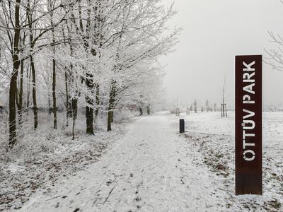Vstup do Ottova parku — tabule s názvem v zimní krajině